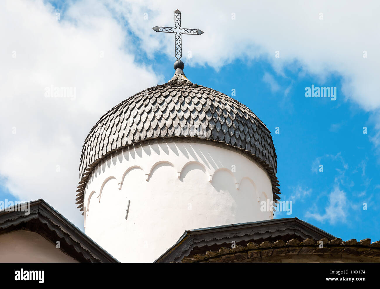 Wooden dome with cross of ancient orthodox church against the blue sky ...