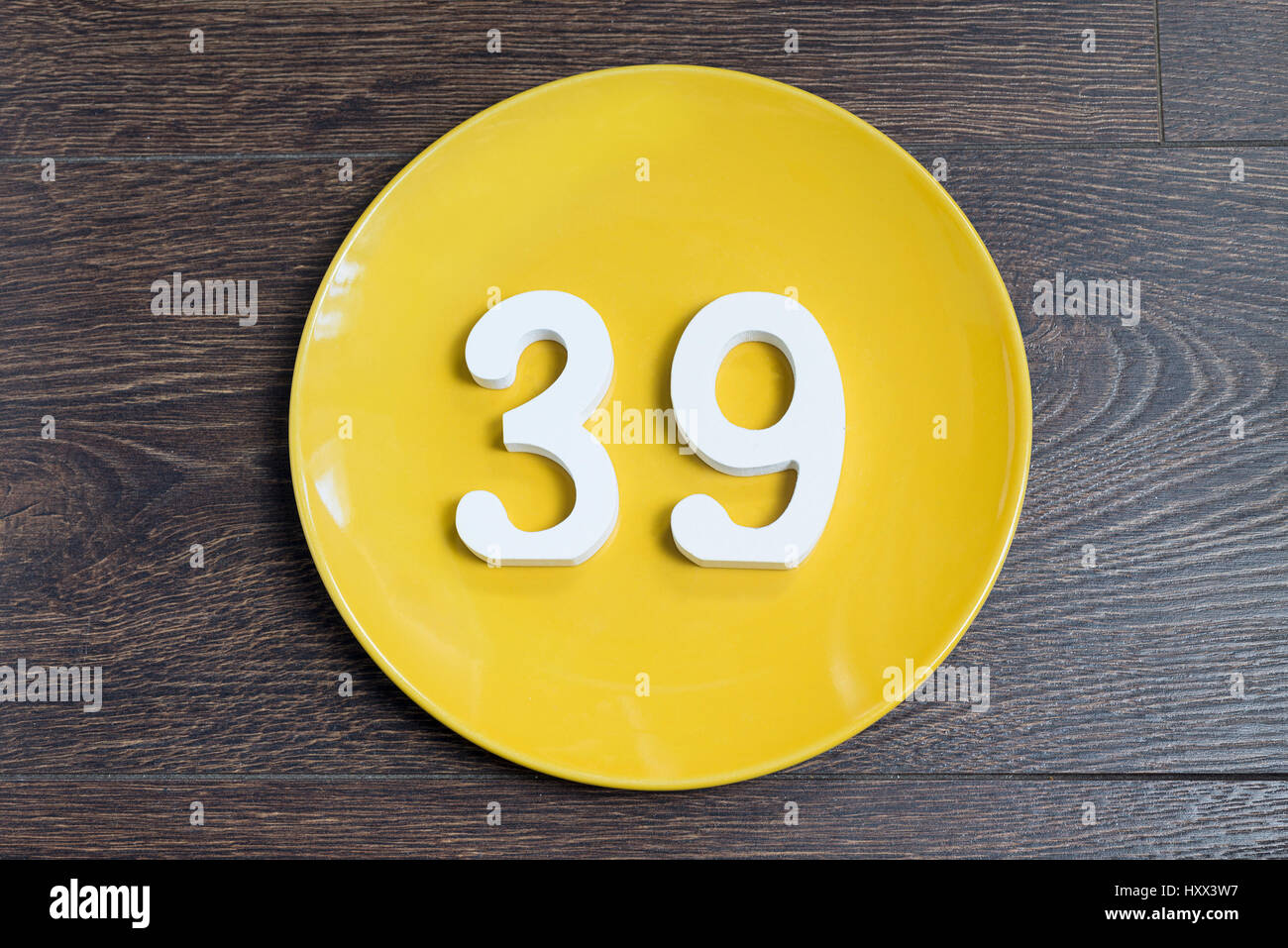 The number thirty-nine on the yellow plate and brown background. Stock Photo