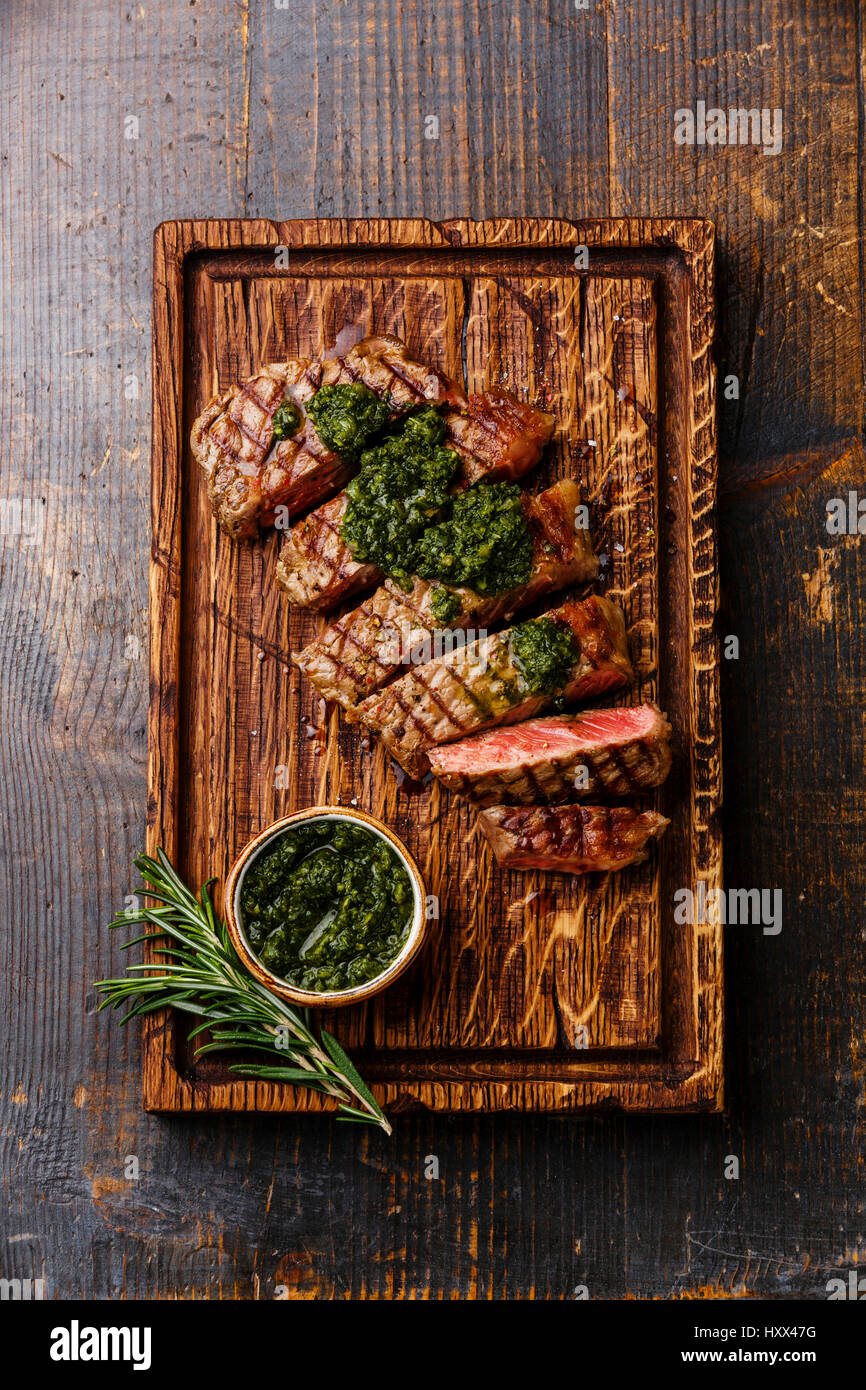 Sliced medium rare grilled beef Sirloin steak with chimichurri sauce on