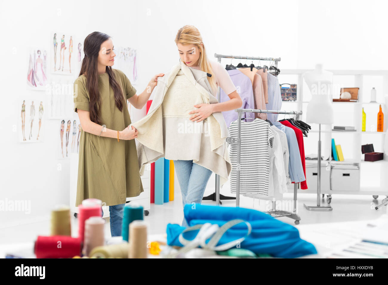 Customer tries new clothing collection of a successful fashion designer in her showroom Stock Photo