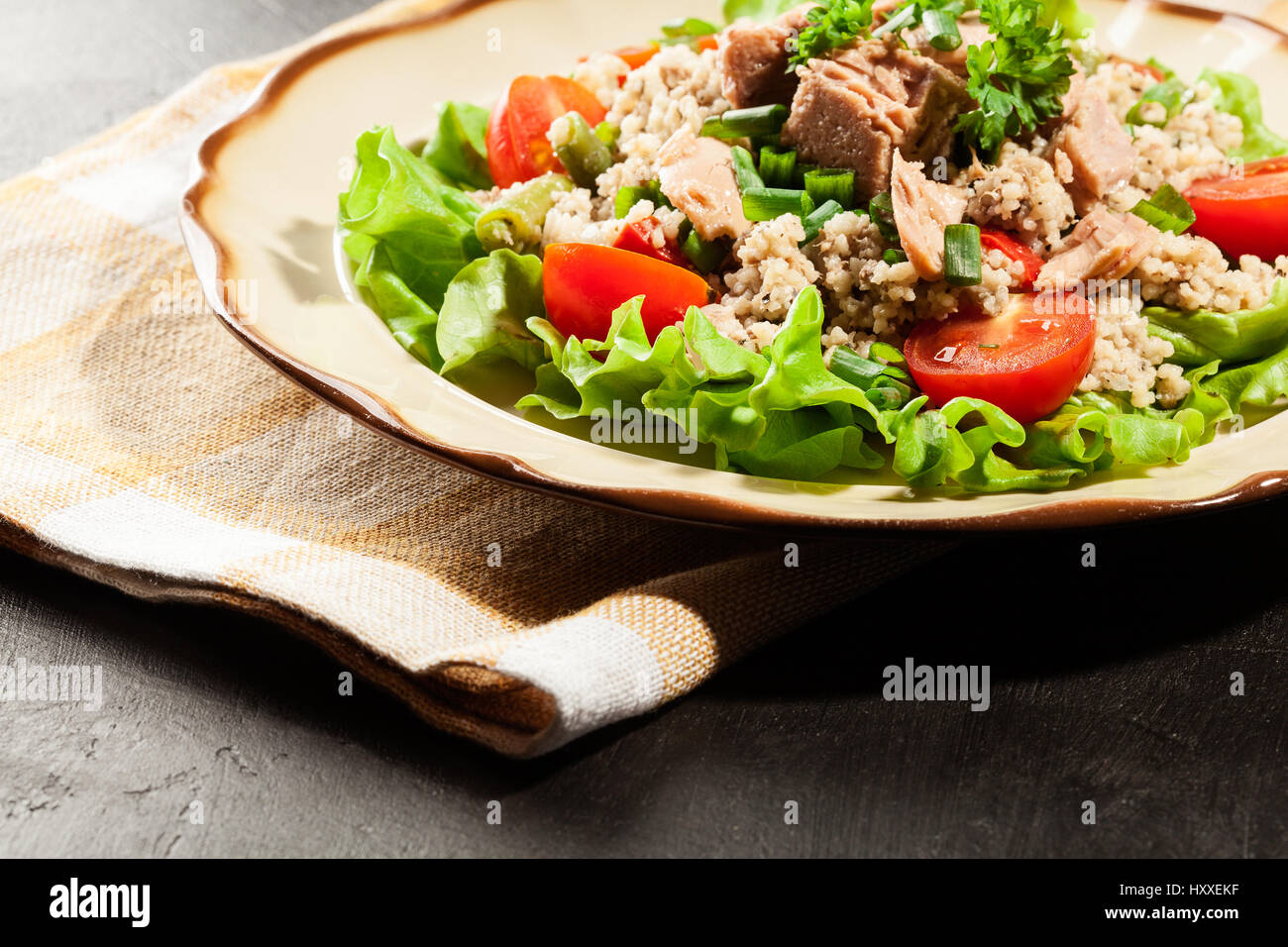 Tasty salad with couscous, tuna and vegetables on the plate Stock Photo