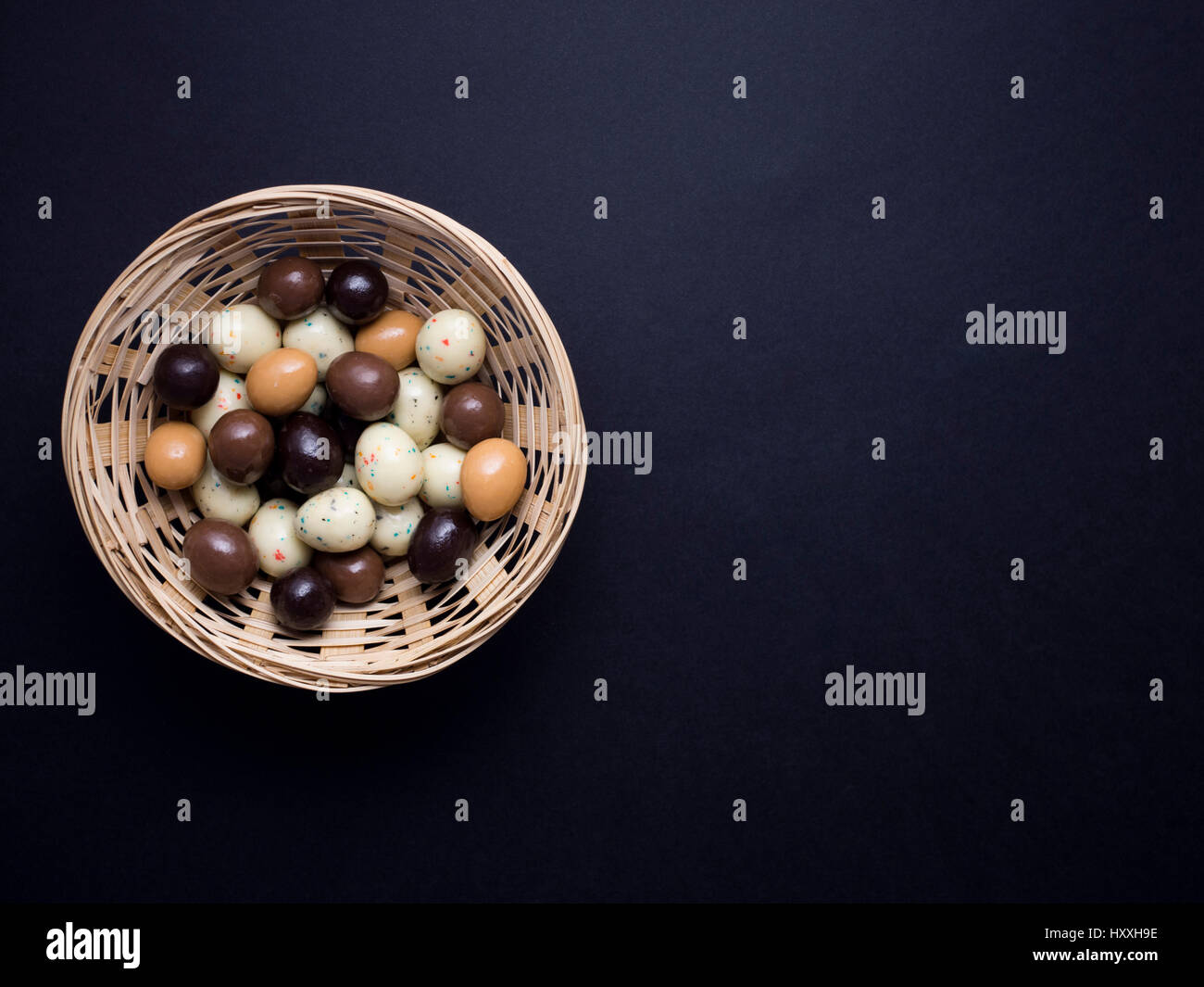 chocolate easter eggs in wooden basket isolated on black background ...