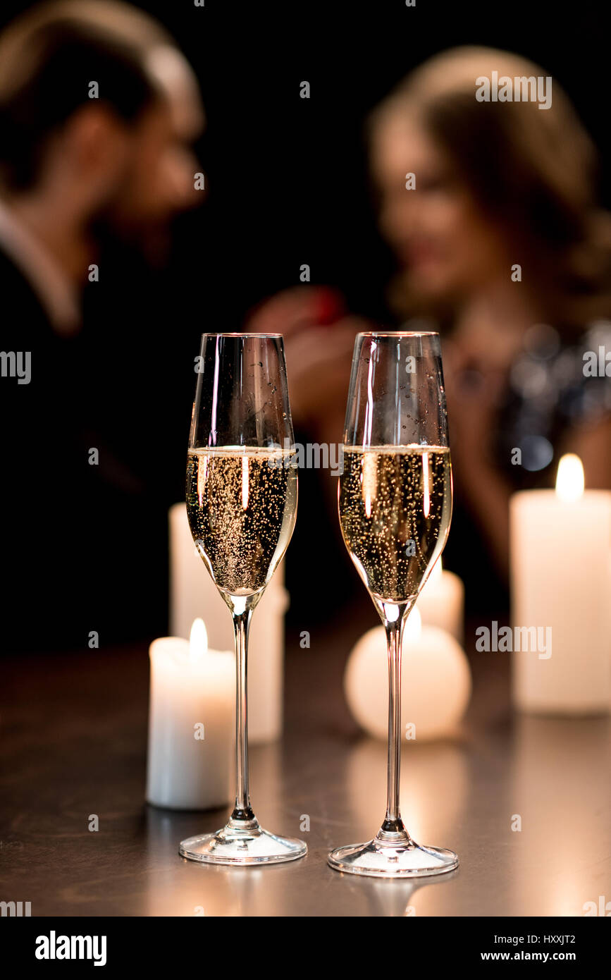 Close-up view of two shiny glasses of champagne and burning candles on table Stock Photo