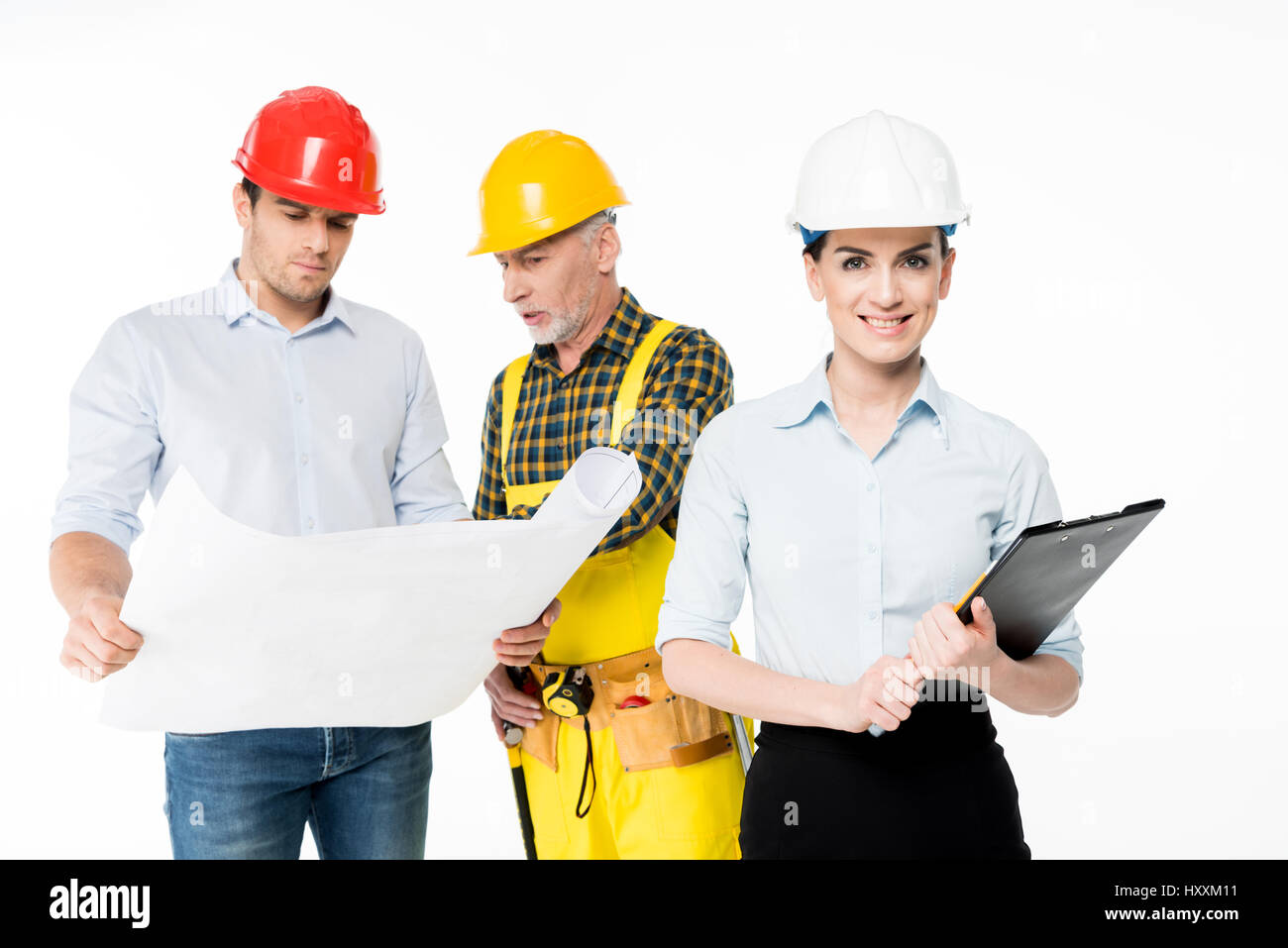 Female architect smiling while her colleagues examining blueprint Stock ...