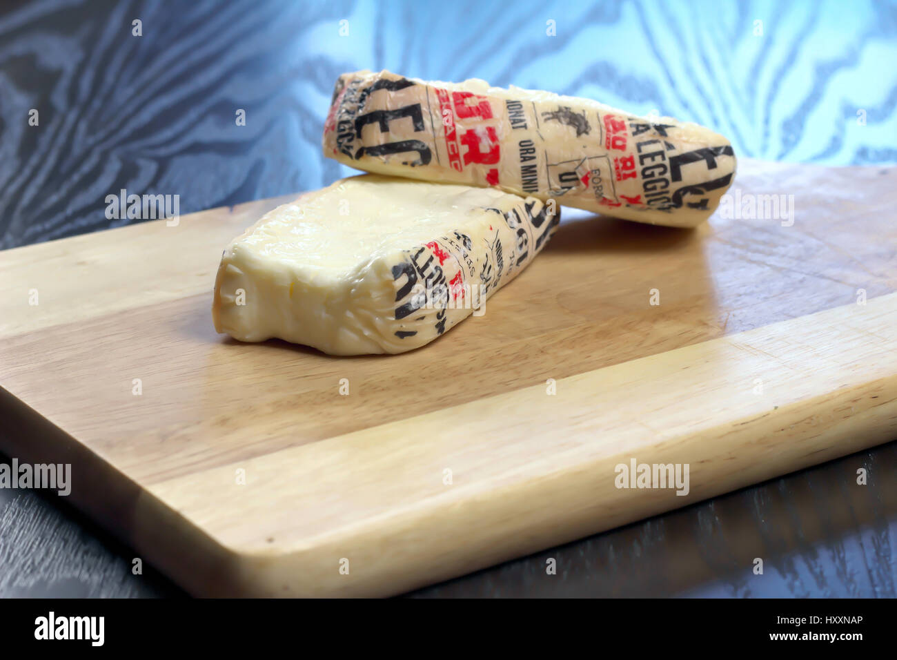 Cut Italian Taleggio Cheese on wooden cutting board - Lombardy typical cheese with strong aroma, but its flavor is mild with an unusual fruity tang Stock Photo