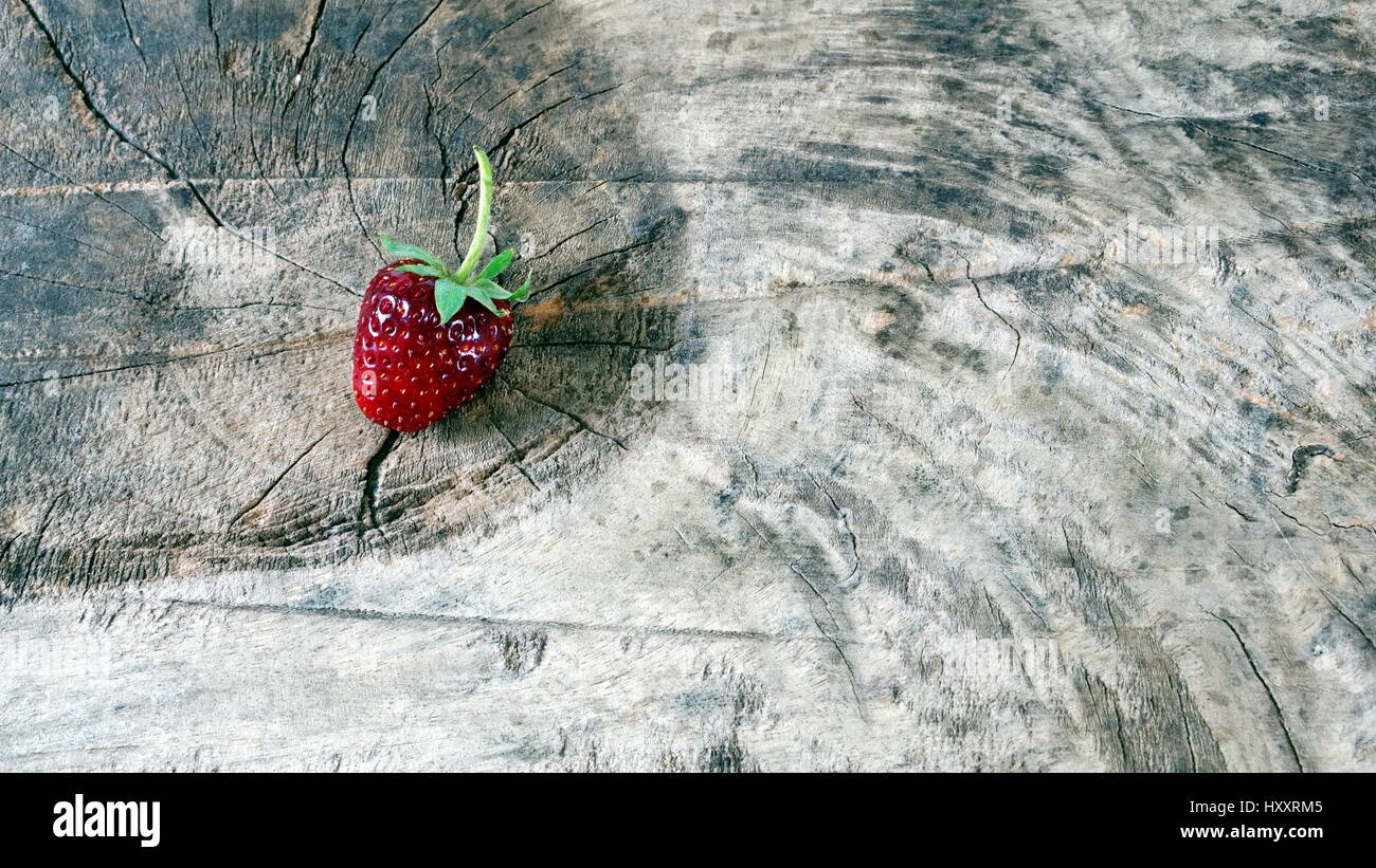 Strawberry on a wood table. Strawberry flavor and fragrance are popular, Strawberry are used widely in a variety of manufacturing, including beverages Stock Photo