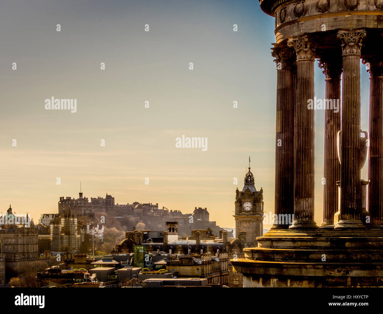 View across Edinburgh from Calton Hill framed with the Dugald Stewart Monument, with Edinburgh Castle and Balmoral Hotel Clocktower in the distance. Stock Photo