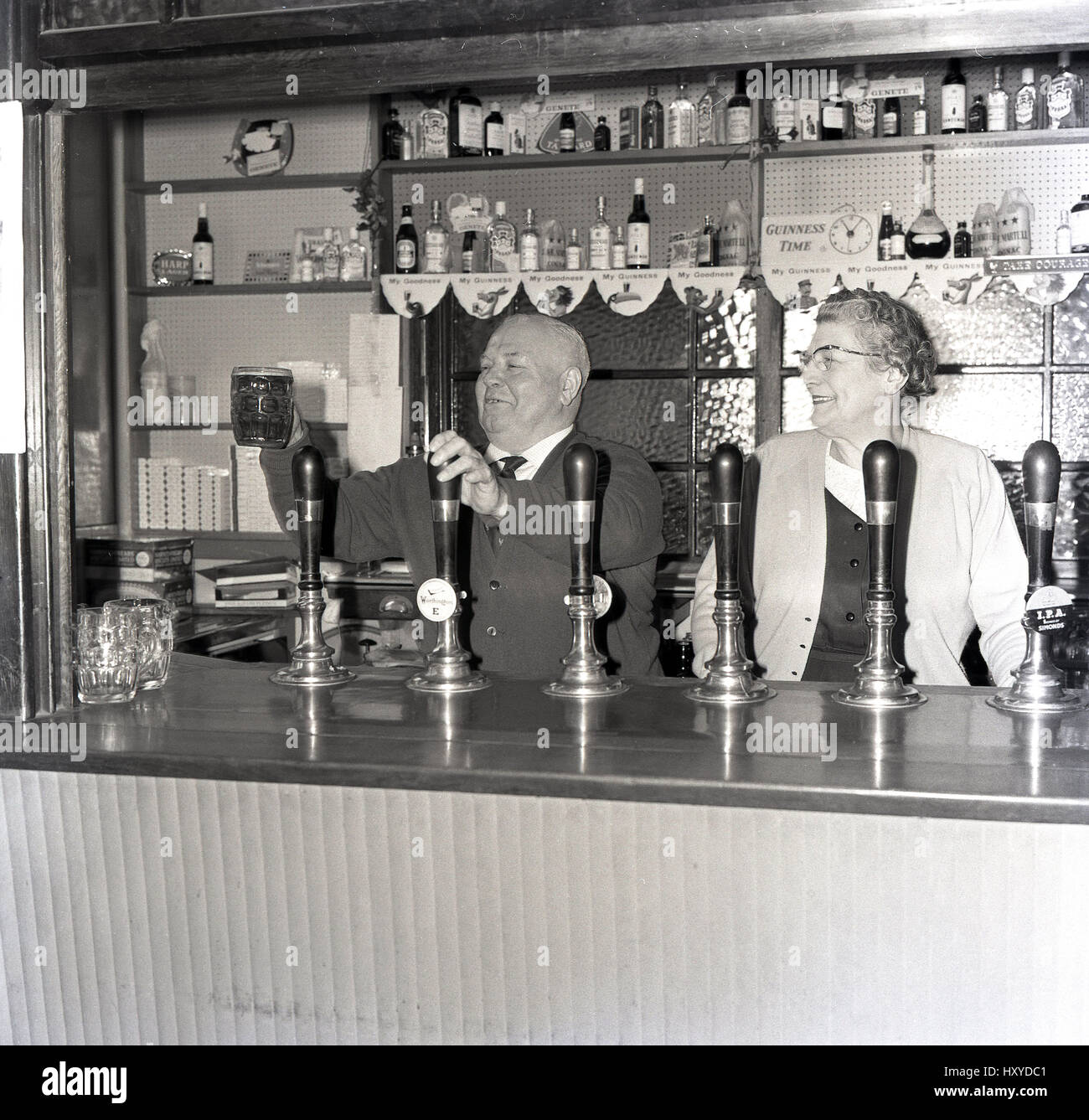 1960s, Historical, 'Cheers'! pub landlord shows off a pint of Worthington's E best bitter, a popular keg beer of the day, England. Stock Photo