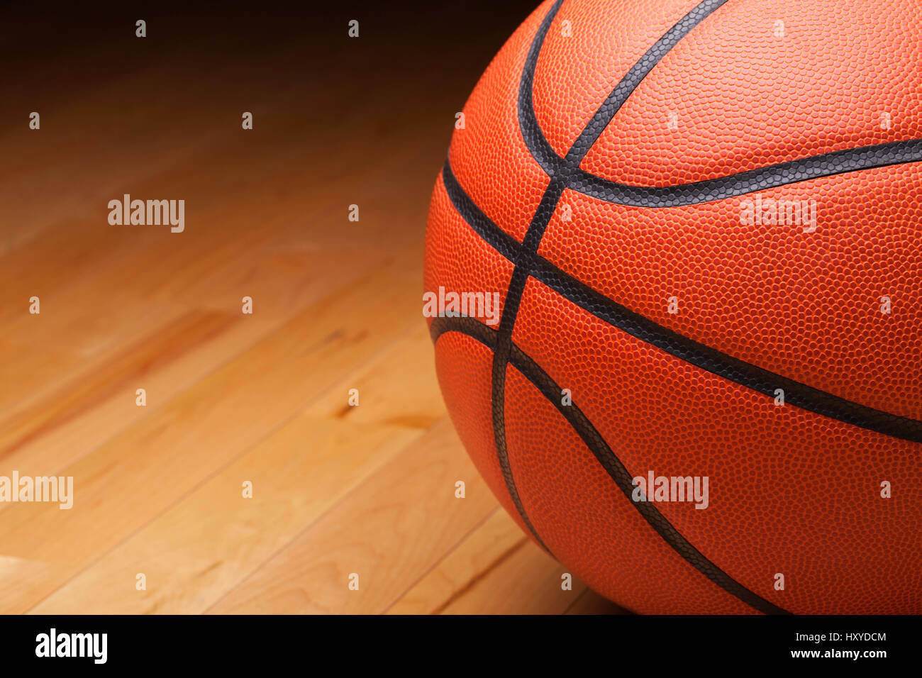 Close up shot of a basketball on a hardwood gym floor Stock Photo