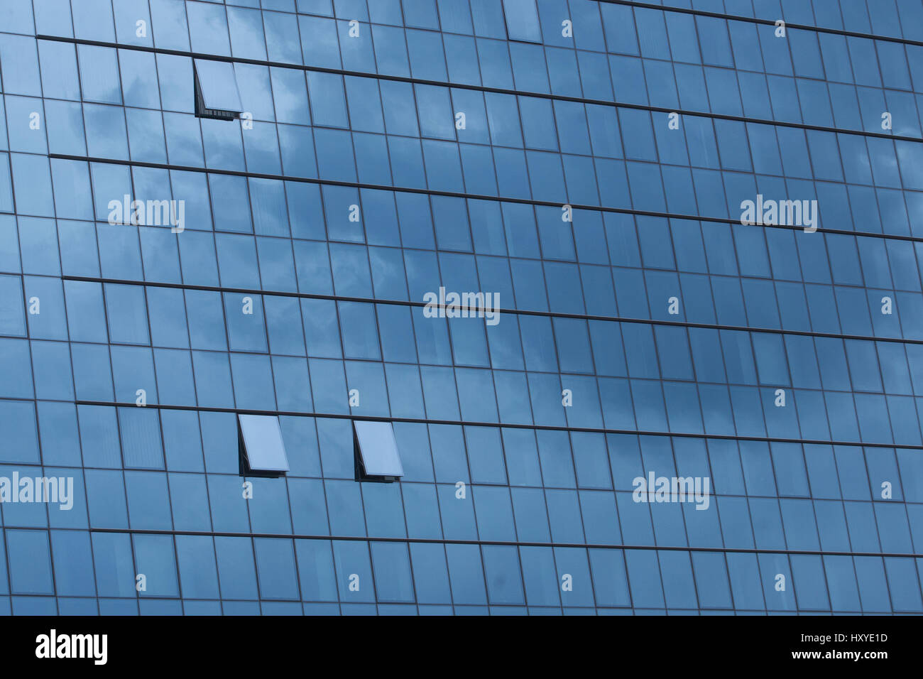 Sky reflecting in windows of office building Stock Photo - Alamy