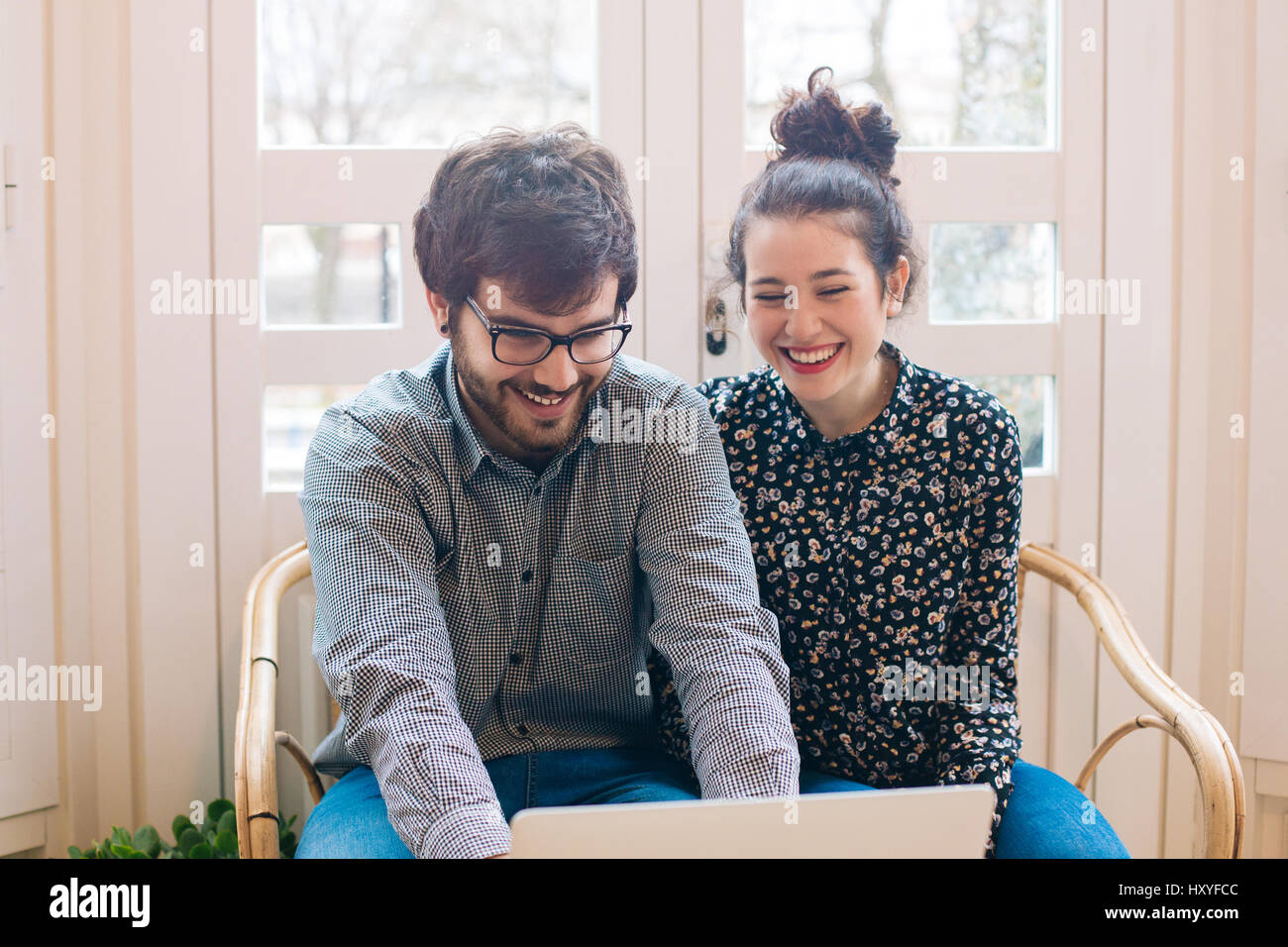 Young attractive couple having fun using a laptop indoors Stock Photo ...