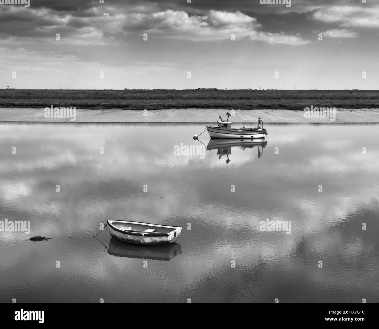Boats moored in calm water, reflections at barling magna Stock Photo