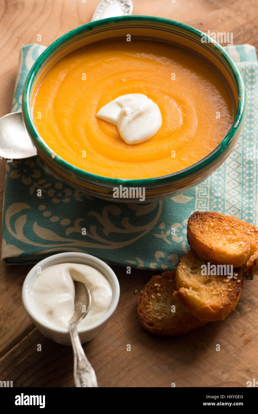 Pumpkin soup in a bowl with coconut cream and fried bread croutons with sesame Stock Photo
