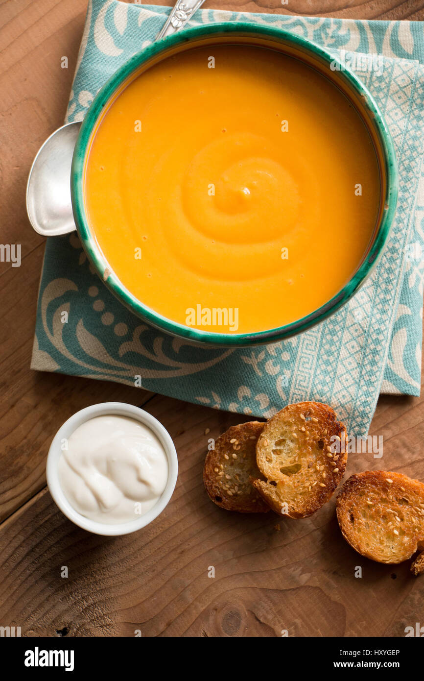 Pumpkin soup in a bowl with coconut cream and fried bread croutons with sesame Stock Photo