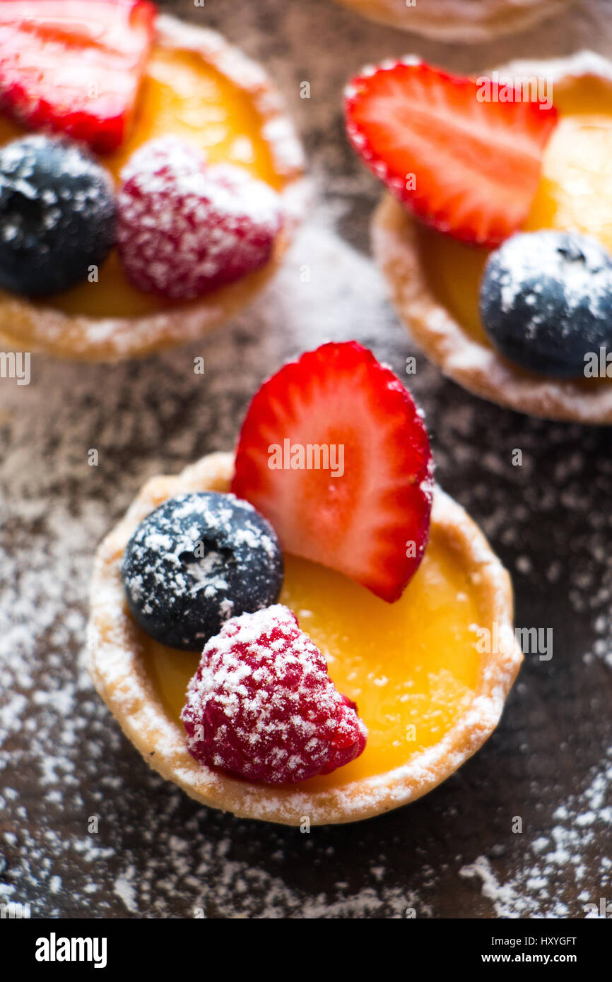 Small tarts of cream and fresh berries with icing sugar Stock Photo Alamy