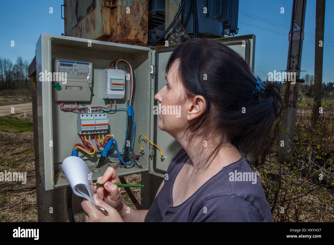 Woman Technician reading the electricity meter to check consumption