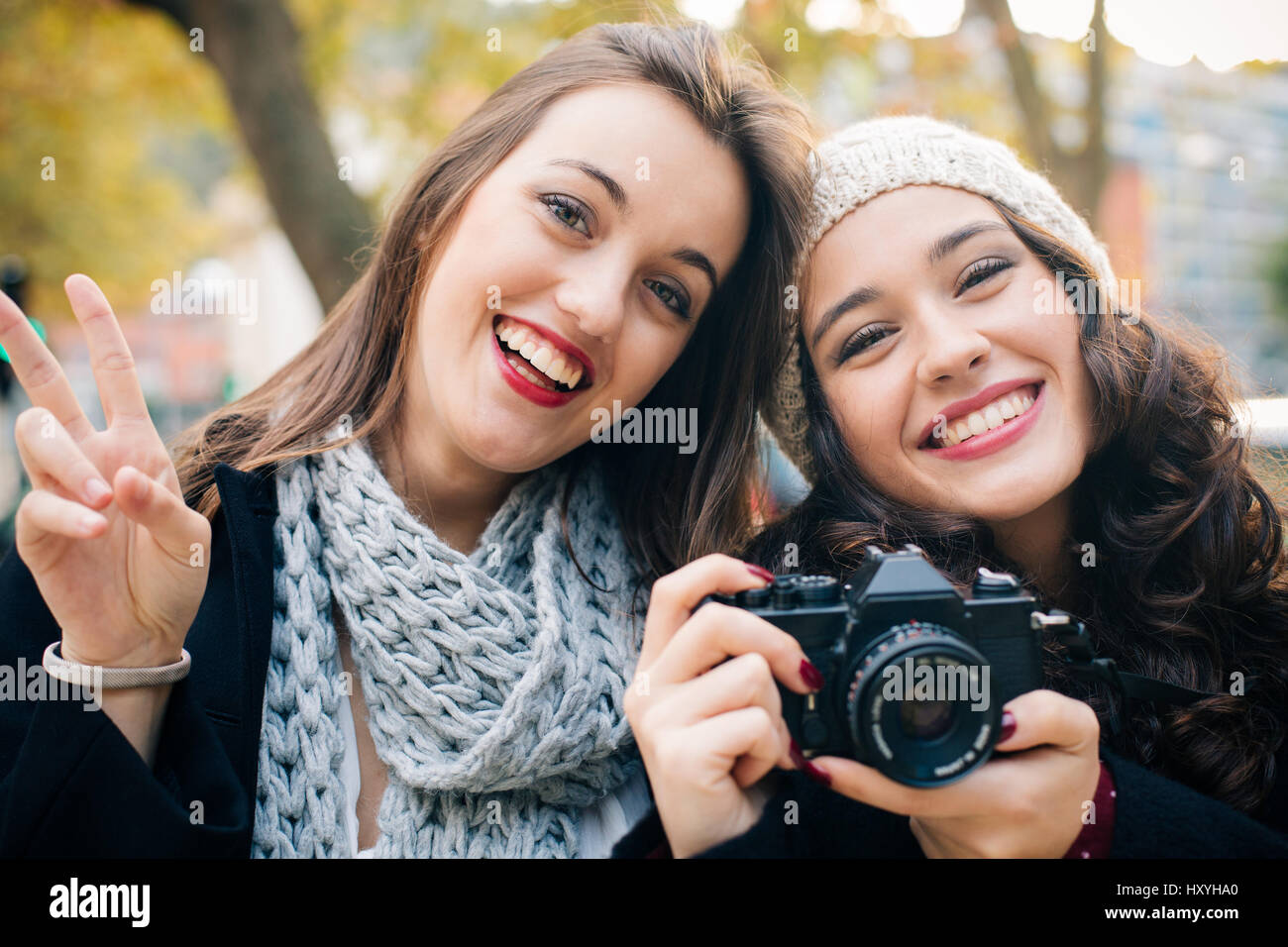 Proud girl friends with an old analog SLR camera outdoors in autumn Stock Photo