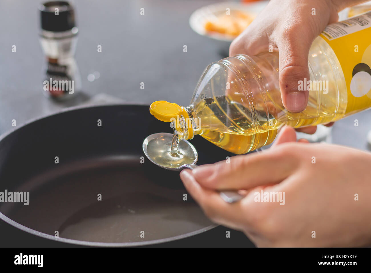 Cook pouring oil into a hot black saucepan Stock Photo Alamy