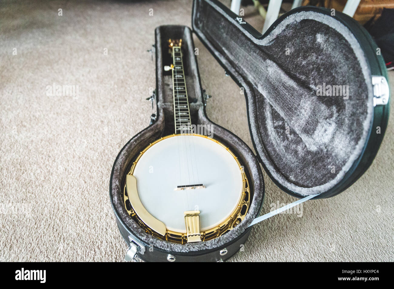 High-value banjo in custom hard case. Banjo has mahogany body and gold accents. Stock Photo