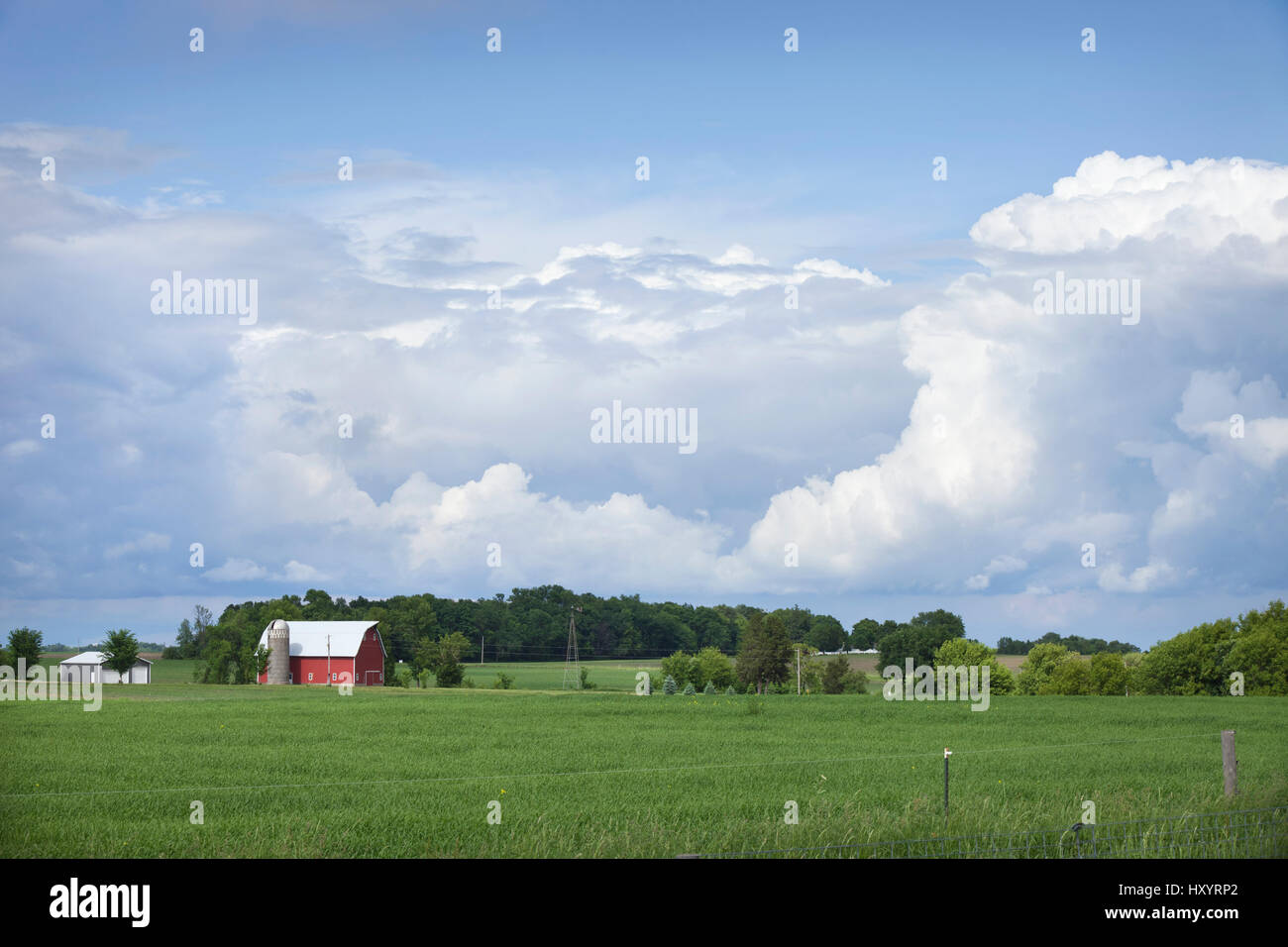 A red barn and field of midwestern farm below dramatic cloudscape Stock ...