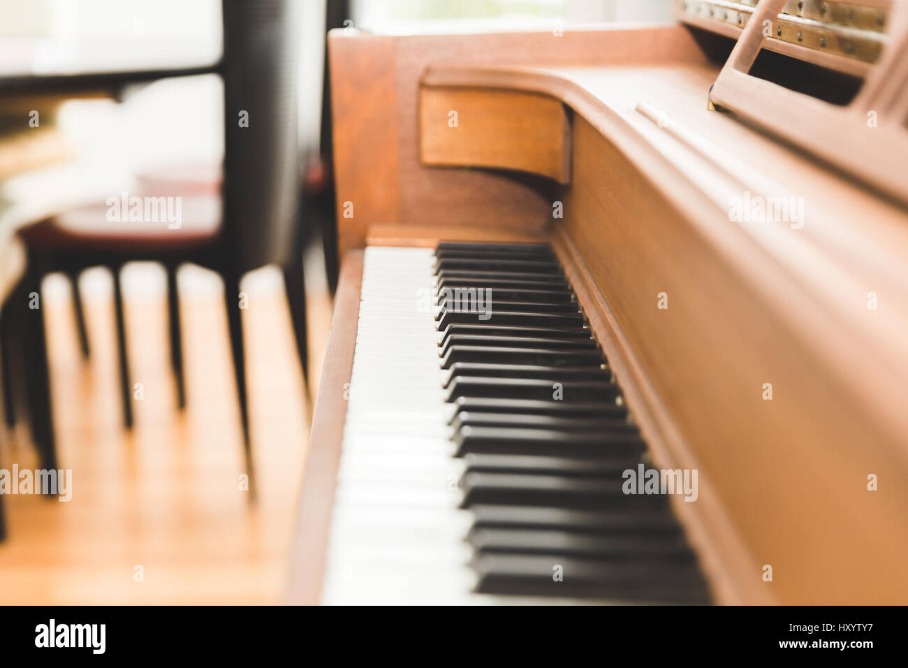 Black and white piano keys on a wooden upright piano. Stock Photo