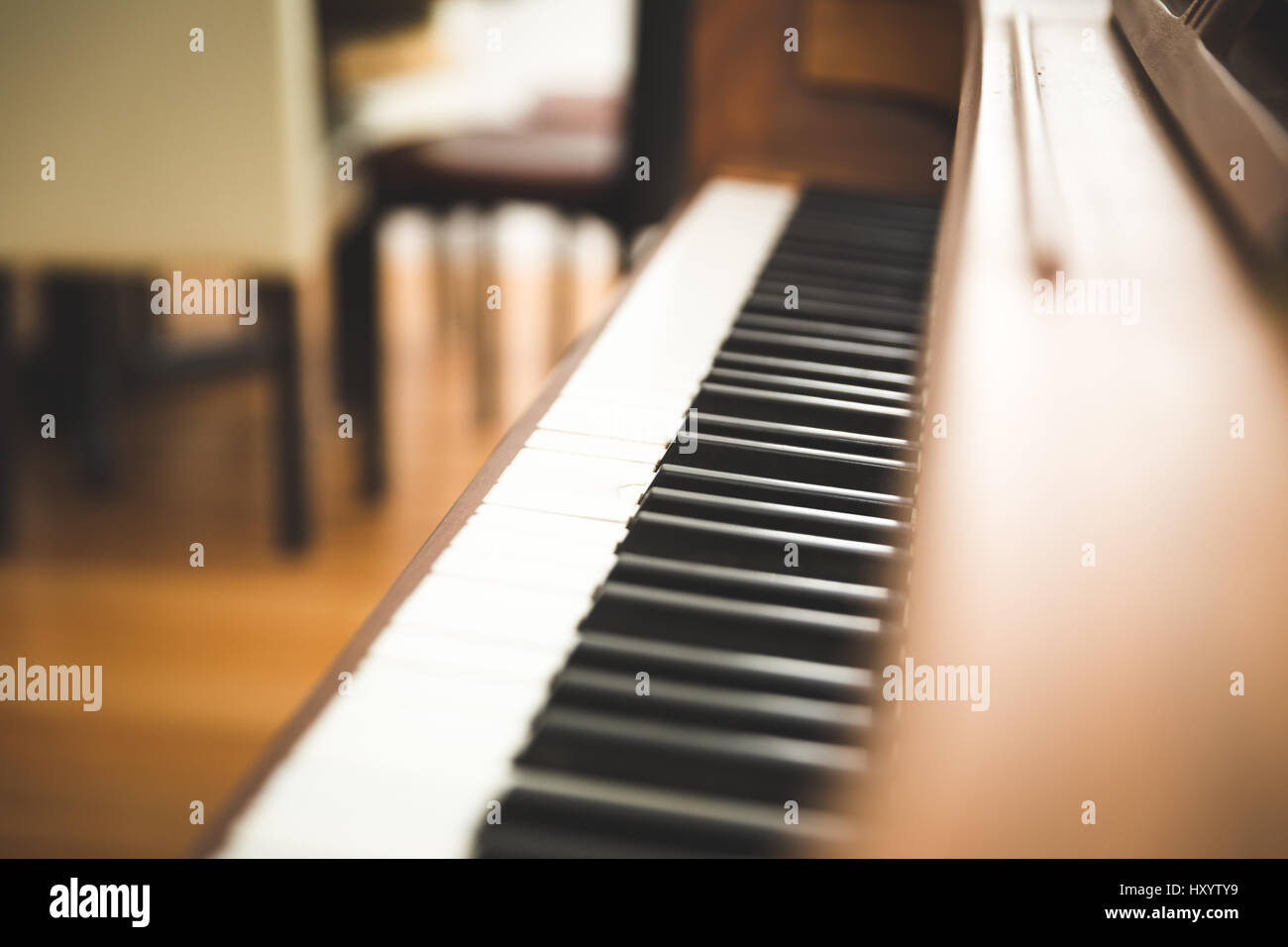 Black and white piano keys on a wooden upright piano. Stock Photo