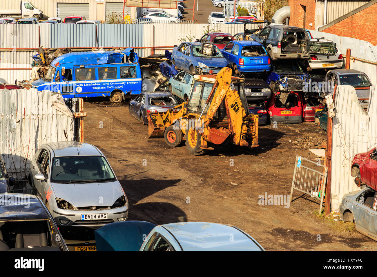GRIMSBY, ENGLAND MARCH 14 Working yellow JCB digger amidst scrapped