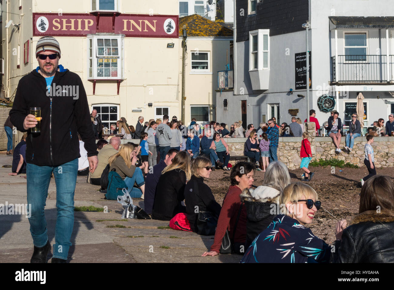 Crowds of people outside the Ship Inn, Teignmouth, Devon UK, enjoying evening sunshine and a drink. Stock Photo