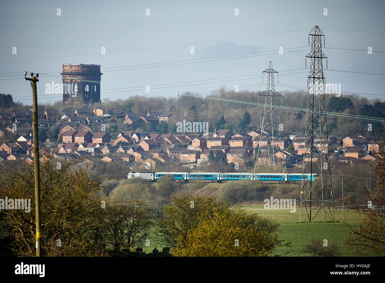 Arriva Trains Wales passing, on a Manchester to Wales service Norton Water Tower Cheshire, England. UK. Stock Photo