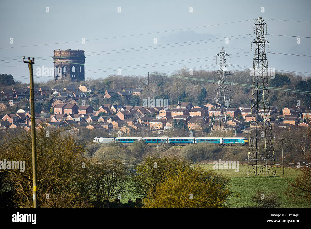 Arriva Trains Wales passing, on a Manchester to Wales service Norton Water Tower Cheshire, England. UK. Stock Photo
