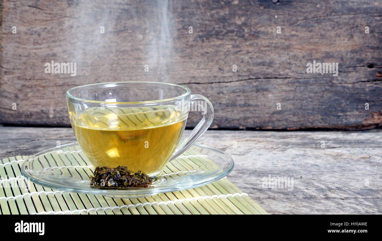 Hot tea in the morning. A Cup of tea on the wood desk with flowers background Stock Photo