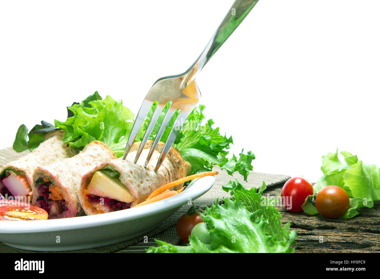 the fresh whole wheat bread wraps with vegetables and fruit on the plate, healthy and clean food