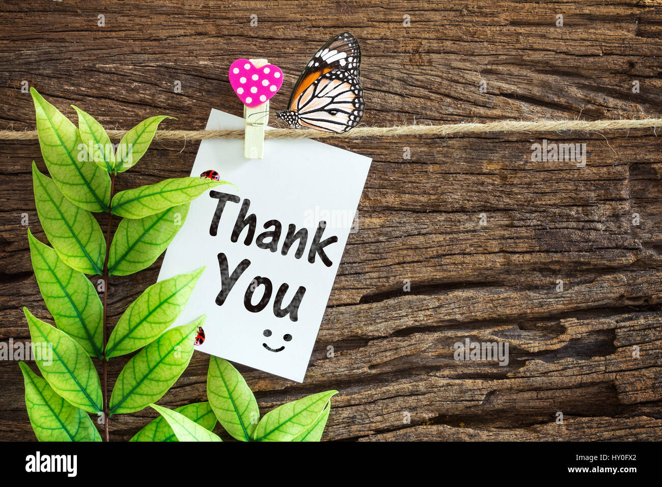 Thank you paper note hanging by red heart clips on wooden ...