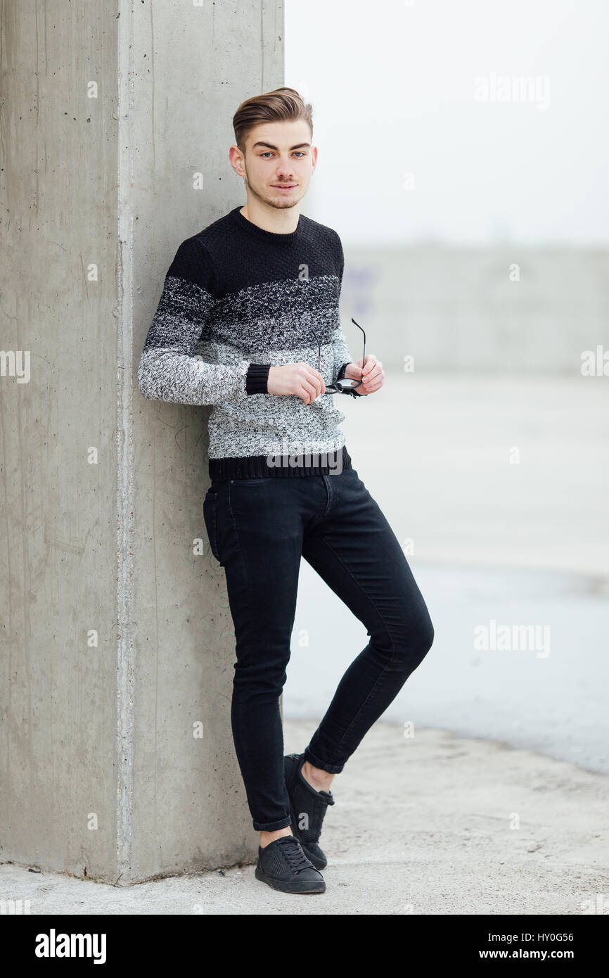 handsome and cool young man posing against a brick wall and smiling to  camera, lifstyle picture with a modern student - Stock Image - Everypixel