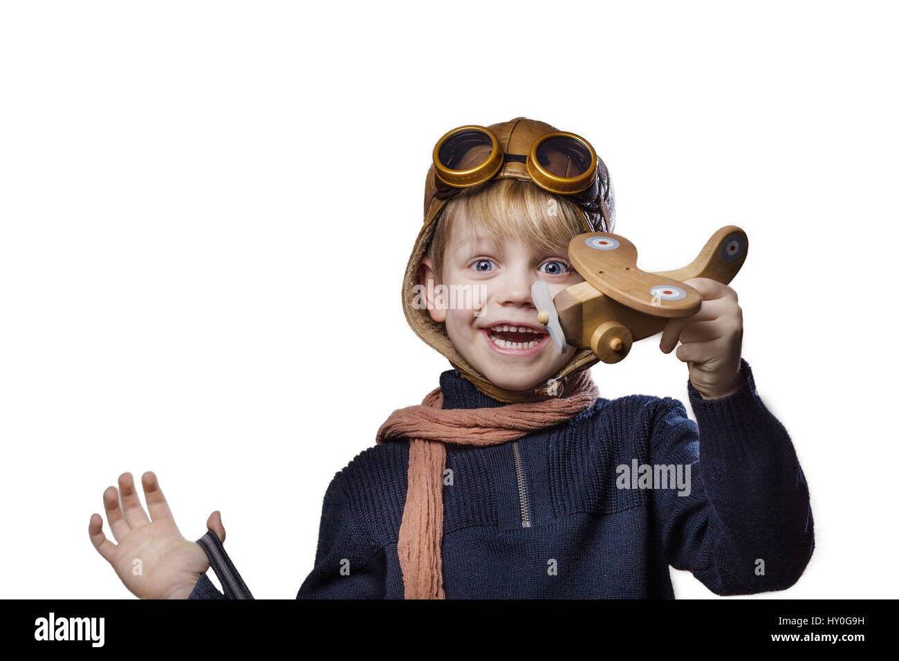 Happy child dressed in pilot hat and glasses. Kid playing with wooden ...