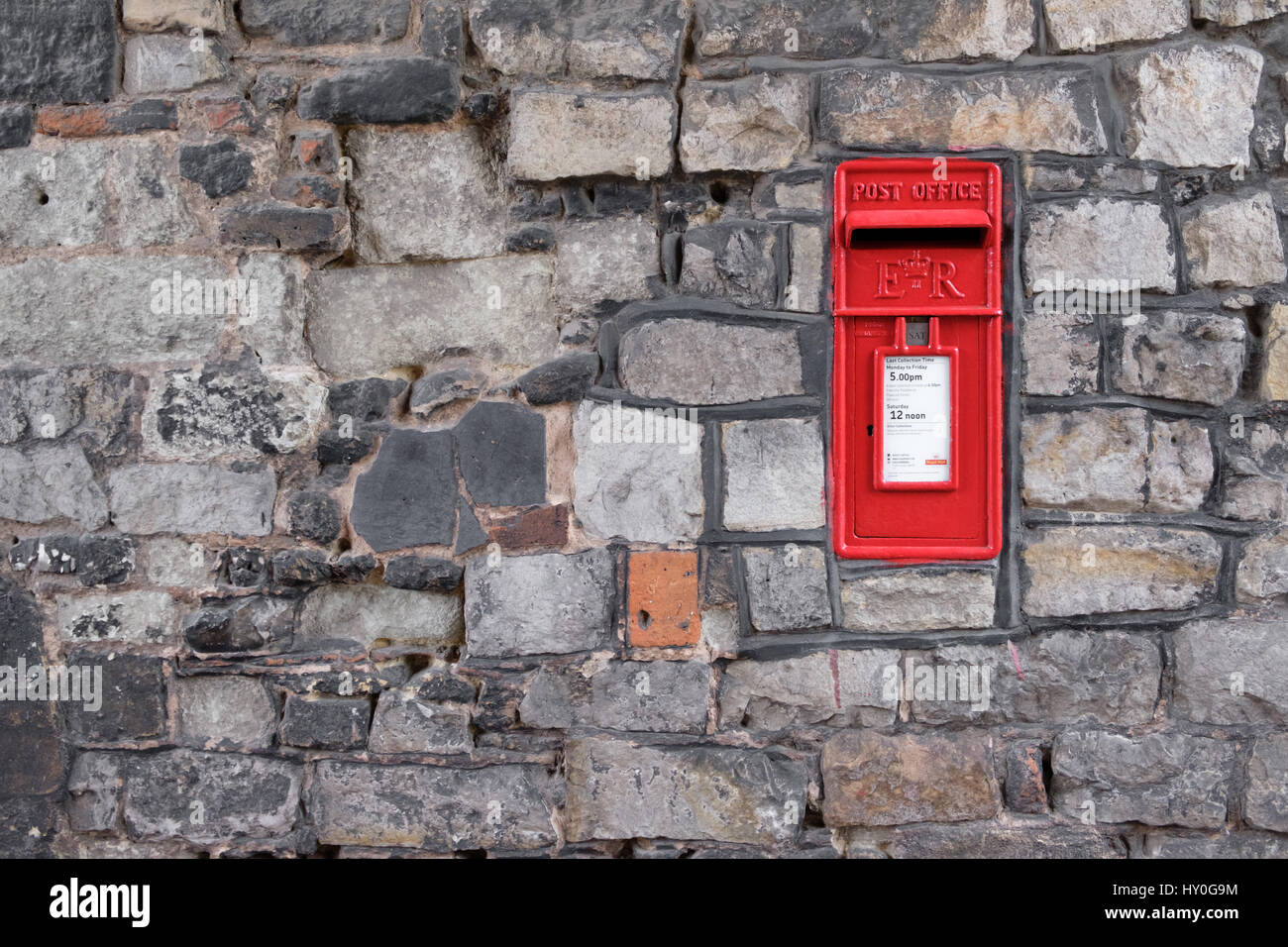 WINDSOR, UK - MARCH 18: A traditional iconic British post box in a stone wall in March 2017.. Stock Photo