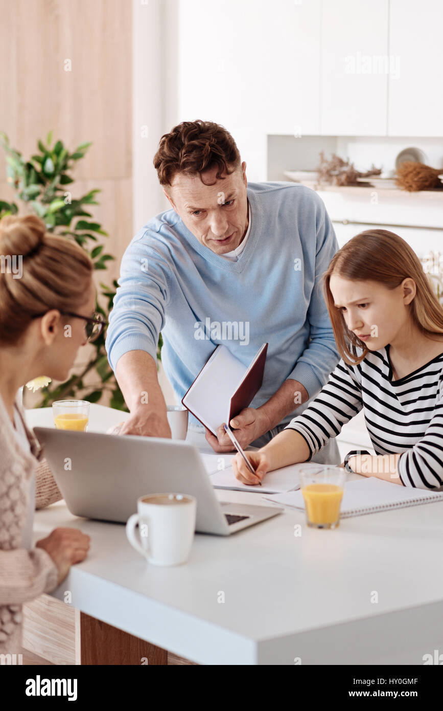 Serious loving parents helping their daughter with homework Stock Photo ...