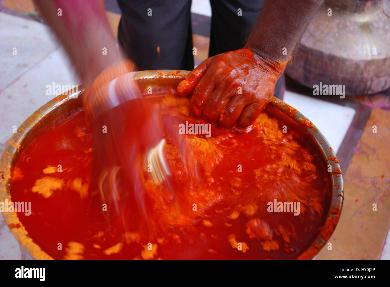Man preparing red wet colour, rangpanchami temple, jodhpur, rajasthan, india, asia Stock Photo