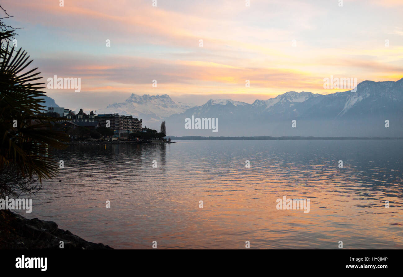 A view along the shore and out across Lake Geneva towards the Alps ...