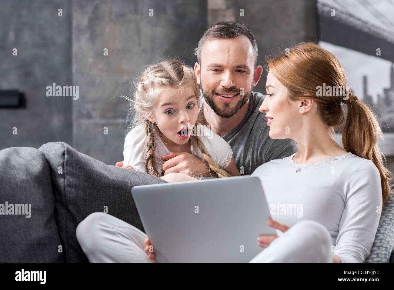 Excited young family using laptop together at home Stock Photo - Alamy