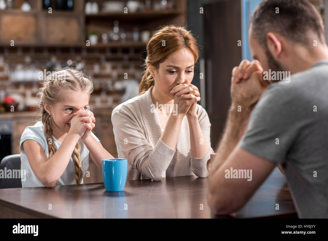 Young family praying sitting table hi-res stock photography and images ...