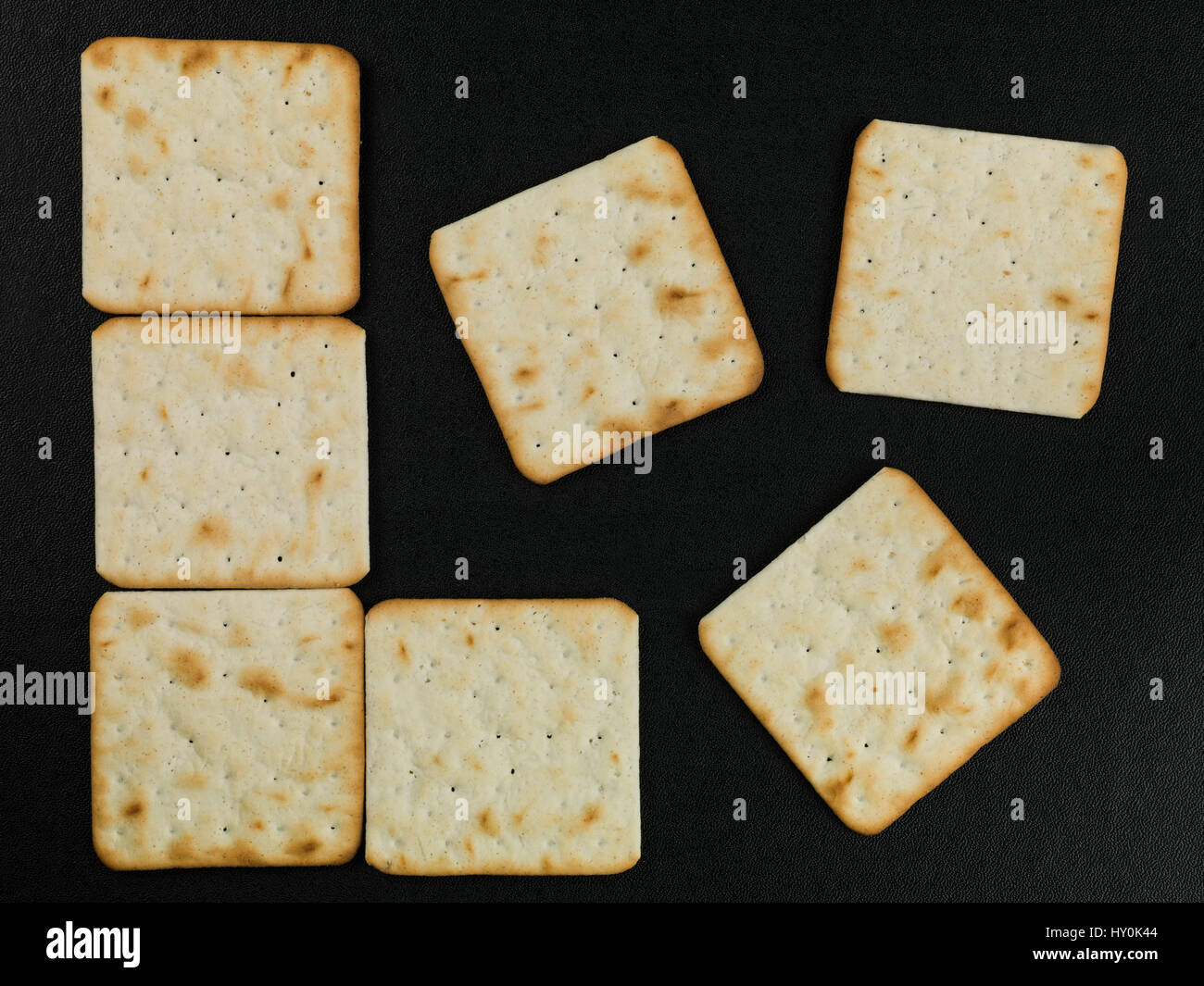Pattern of Dry Cream Crackers Against a Black Background Stock Photo