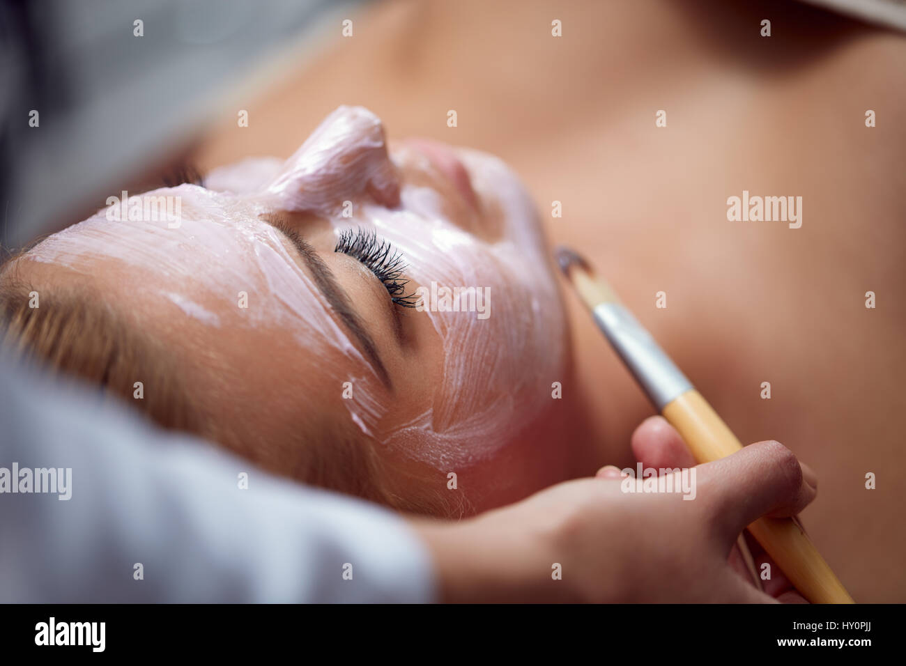 Beautiful young woman having a facial cosmetic treatment. Stock Photo