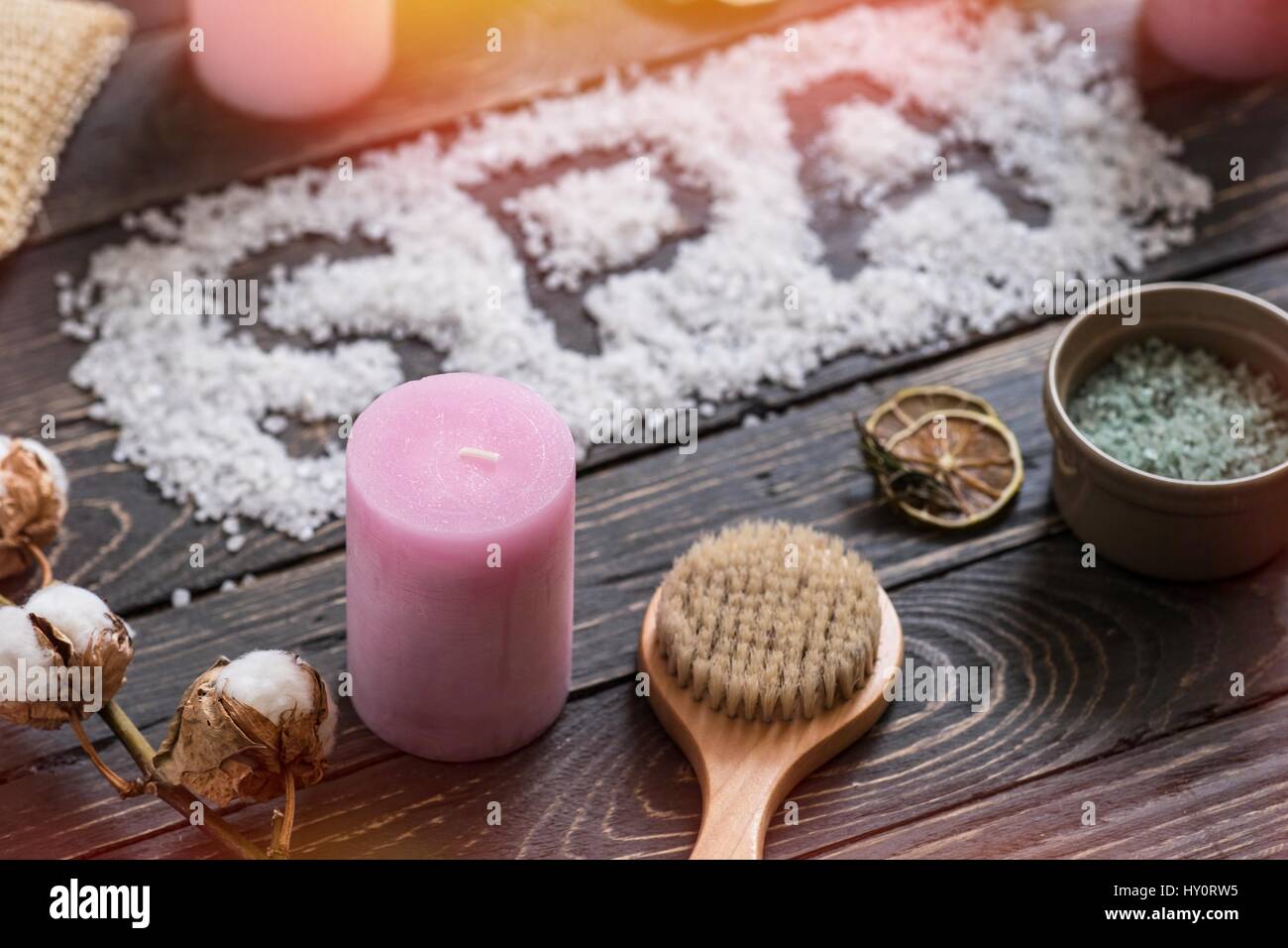 Word SPA with sea salt. Beauty cosmetic products on dark wooden table. Top perspective view. Lighting effects Stock Photo