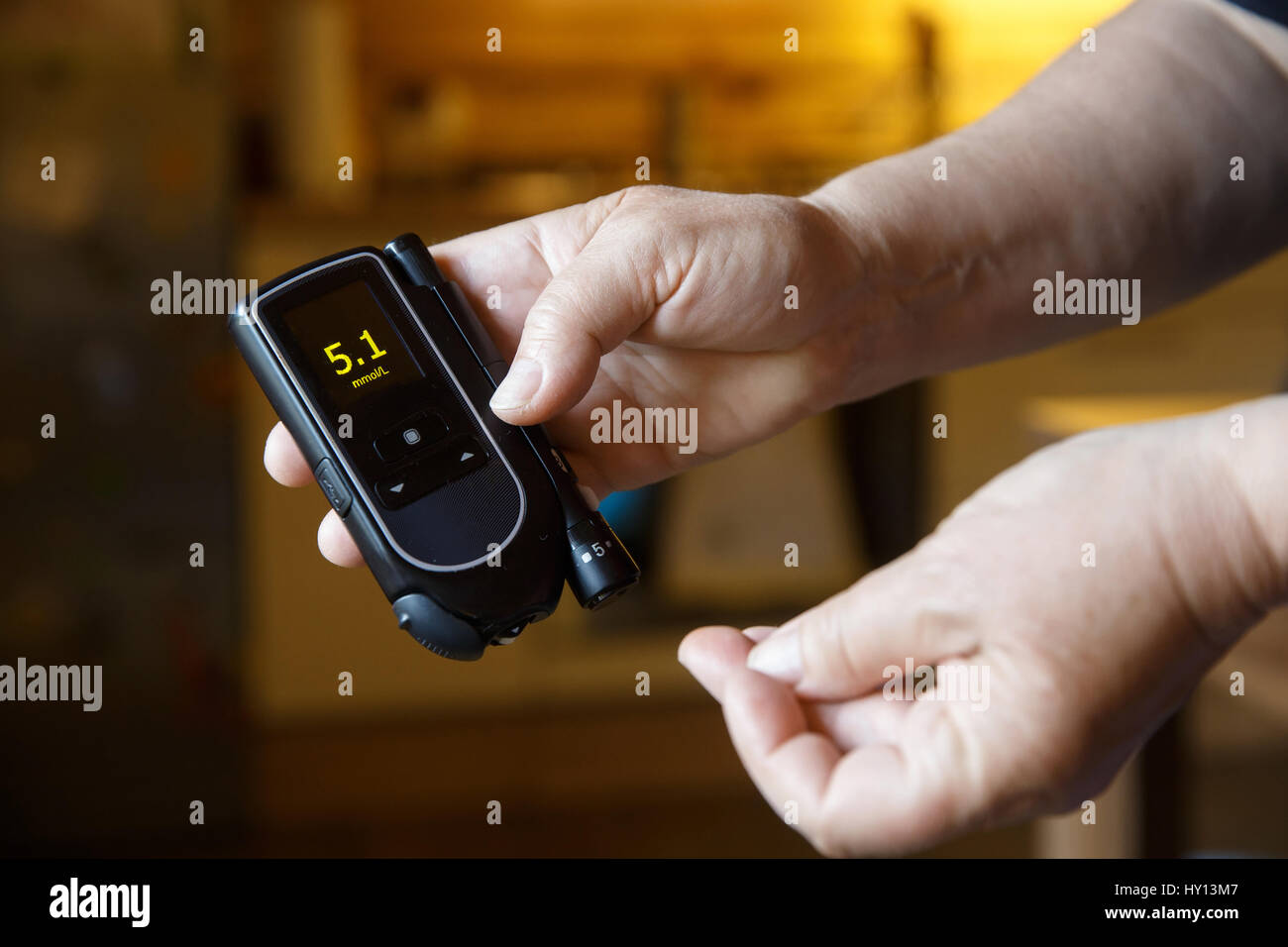 Diabetic patient testing her blood for sugar level at home; normal blood sugar level. Medical process, self-diagnose, common metabolic, widespread and Stock Photo