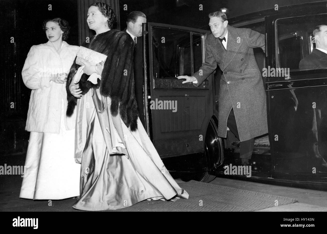 The Queen and Princess Margaret pause for a moment to wait for King Goerge VI to alight from a car as they arrive at the Theatre Royal, Drury Lane, London, to see a performance of the American musical 'South Pacific'. The occasion was a Royal Family party on the eve of the departure of Princess Elizabeth and the Duke of Edinburgh (who also attended the theatre) on their Commonwealth tour. It was the King's first visit to a theatre since his illness. Stock Photo