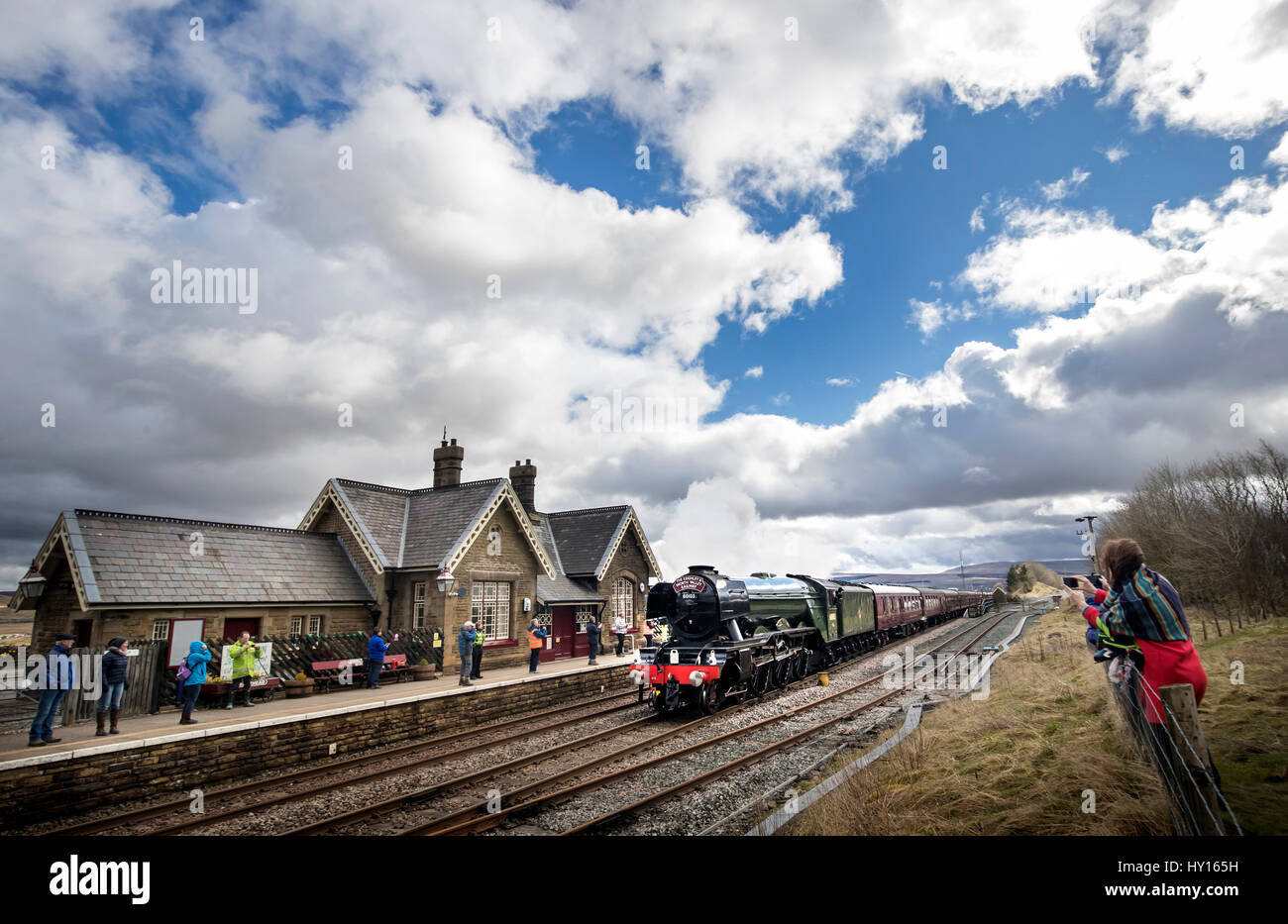 The Flying Scotsman passes Ribblehead Train Station in the Yorkshire Dales National Park, as the Settle-Carlisle railway line reopens after floods. Stock Photo
