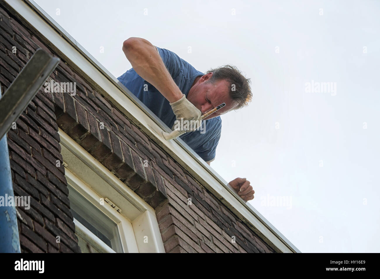 Professional painter at work on exterior of house Stock Photo