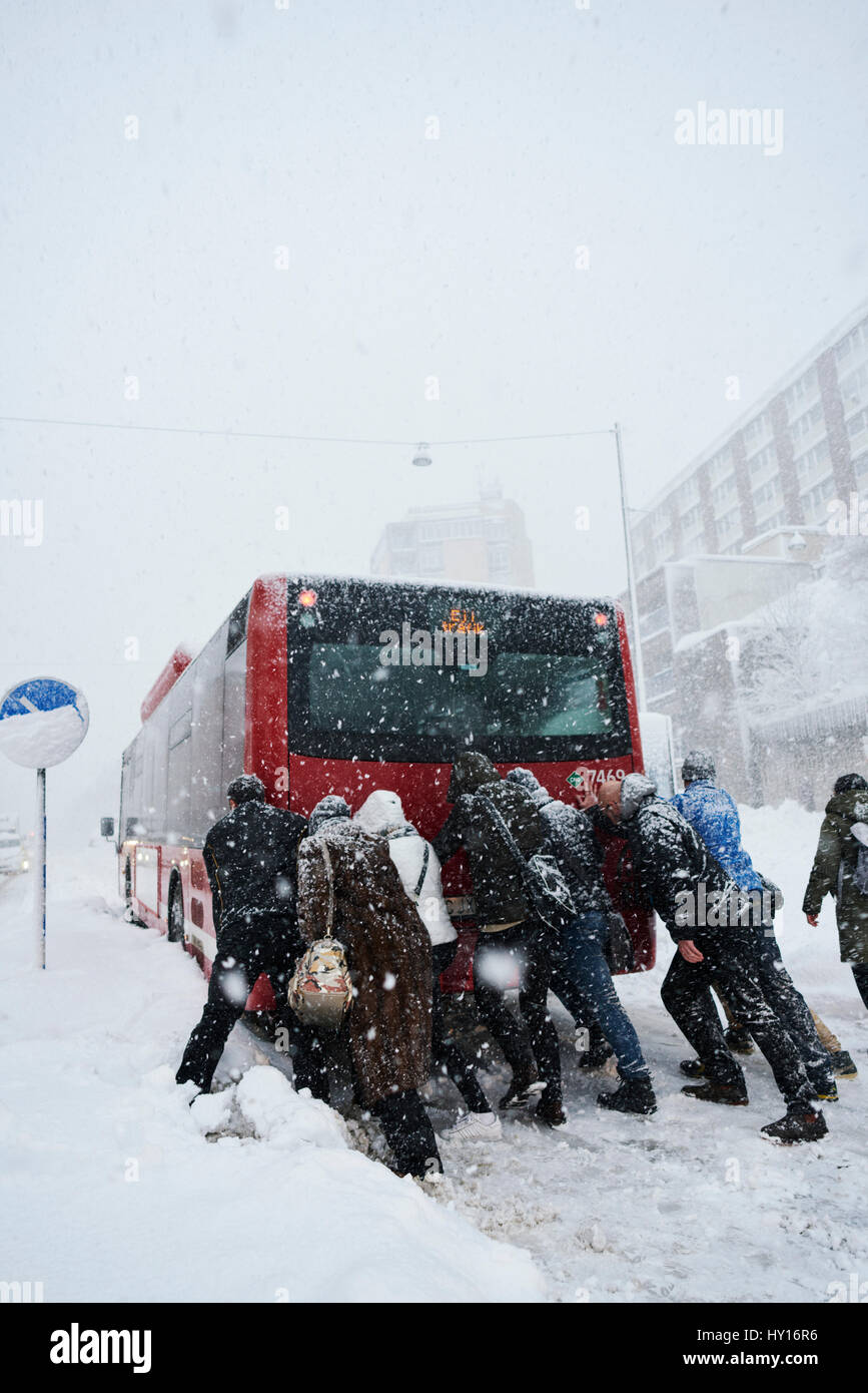 Sweden, Stockholm, Sodermalm, Folkungagatan, People pushing bus in winter Stock Photo