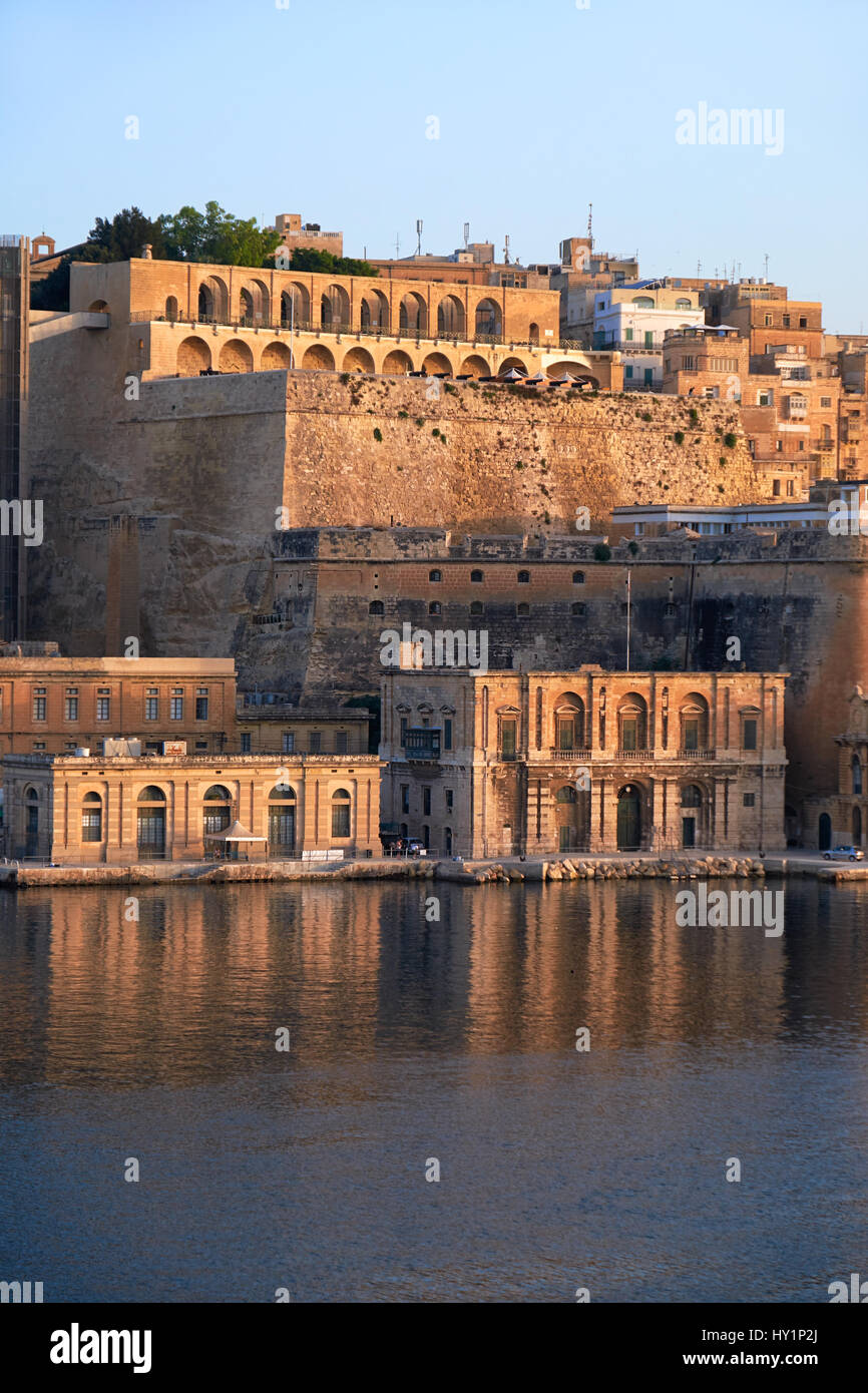 The early morning view of Valletta capital city fortifications with Fort Lascaris and Upper and Lower Barrakka Gardens  from the water of Grand Harbou Stock Photo